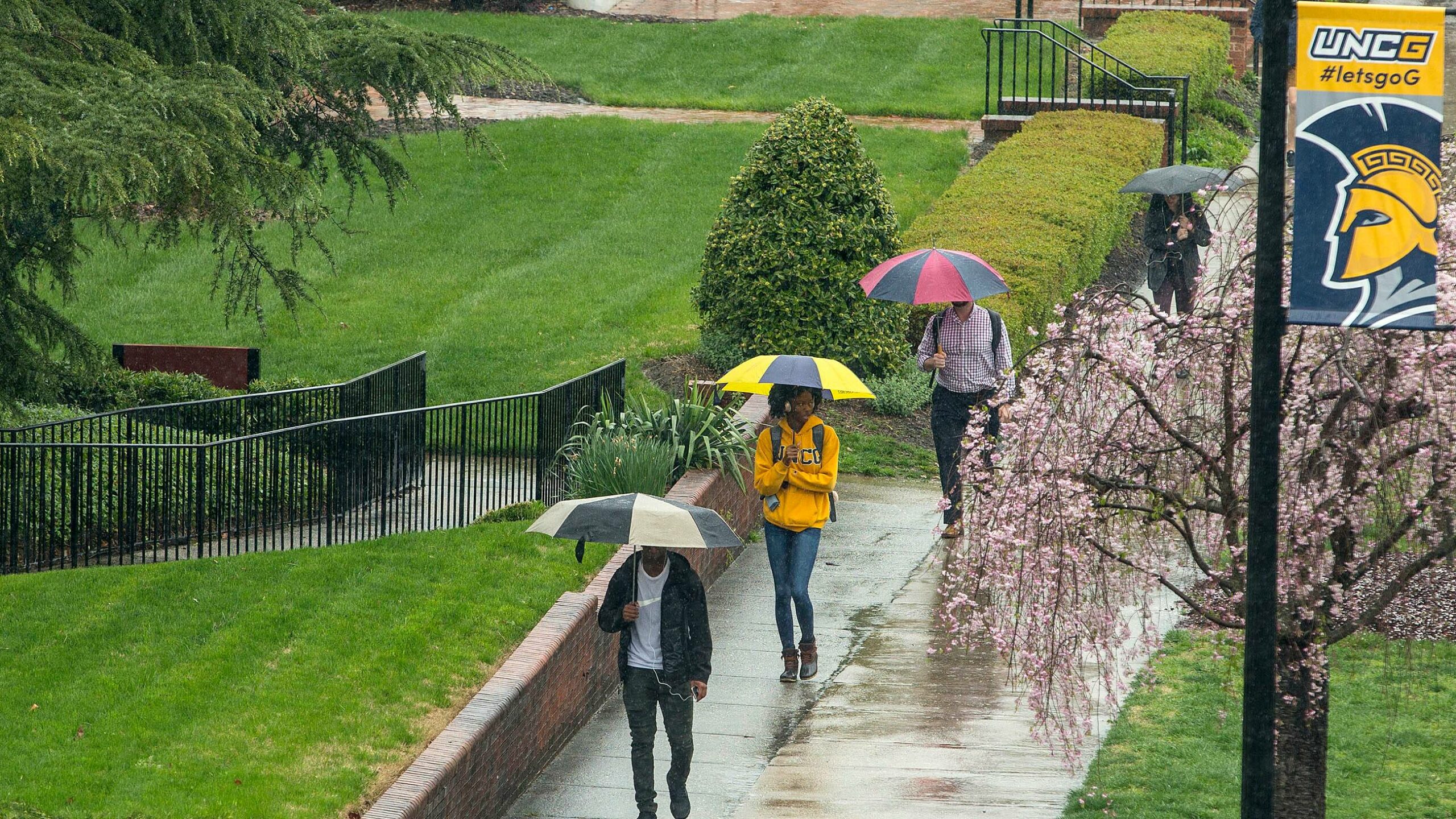 UNCG students walking in the rain.